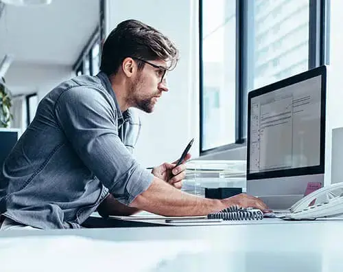 Focused professional working on a computer in a modern office